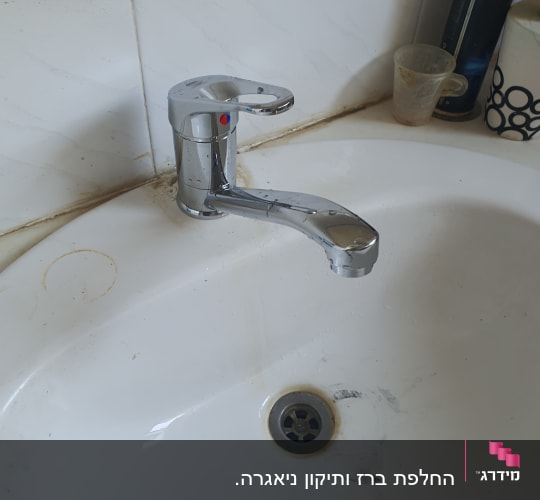 ברז כרום בכיור עם כתמי לכלוך